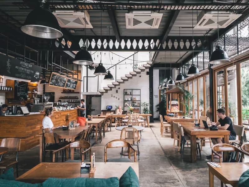 Salón con mesas de madera y lámparas colgantes